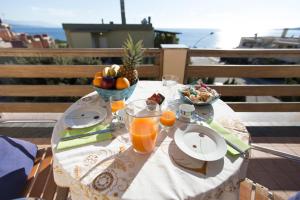 a table with a bowl of fruit and a bowl of orange juice at Elena House in Alghero