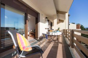 un patio con tavolo e sedie sul balcone. di Elena House ad Alghero