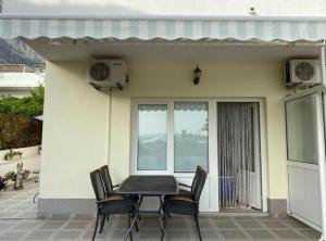 Una mesa y sillas frente a una casa en Apartments Katija, en Baška Voda