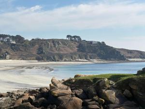 a view of a beach with rocks and the ocean at Maison 3* à Trébeurden: jardin clos, 2 chambres, proche plage et sentiers - FR-1-542-46 in Trébeurden