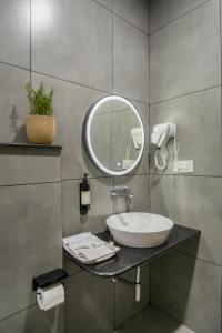 a bathroom with a sink and a mirror at Madras Chronicle Bay Resort & Spa in Mahabalipuram