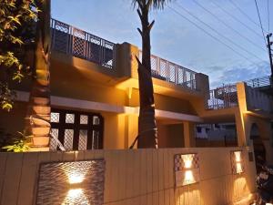 a yellow house with a fence in front of it at A Cozy Villa In Rishikesh-The Figtree Inn in Rishīkesh