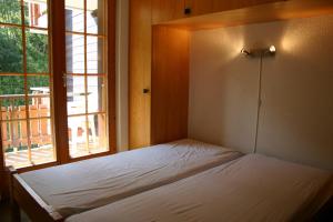 a bed in a room with a window at Mayens de l Ours AZ 013 - MOUNTAIN apartment 8p in Agettes