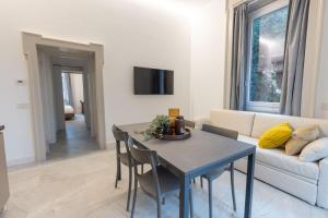 un soggiorno con un tavolo e un divano di Villa Magenta Rho Fair & Station a Rho