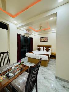 浦那Hotel Fun Suite- Baner Hill的酒店客房配有一张床和一张餐桌。 更多26张照片