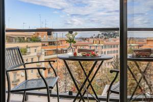 un tavolo e sedie su un balcone con vista di Starhotels Michelangelo Rome a Roma