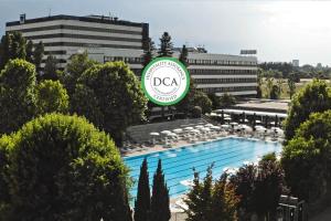 a hotel with a pool in front of a building at Living Place Hotel in Villanova