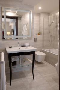 un bagno con lavandino, water e specchio di Starhotels Michelangelo Rome a Roma