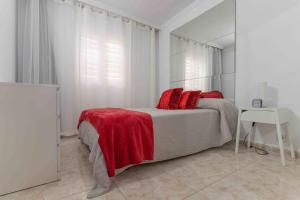 a bedroom with a bed with red pillows on it at Beproud Gc in Maspalomas +16 photos