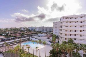 a view of a city with a pool and palm trees at Beproud Gc in Maspalomas