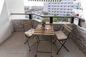 a wooden table and chairs on a balcony at Beproud Gc in Maspalomas