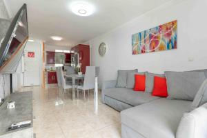 a living room with a gray couch and a table at Beproud Gc in Maspalomas