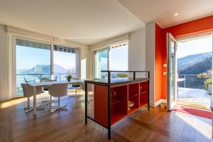 a dining room with orange walls and a table at Panoramic Design Villa on Lake Maggiore! Villa Sfarzoso in Levo +21 photos