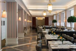 un ristorante con tavoli, sedie e lampadari di Starhotels Michelangelo Rome a Roma