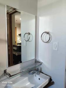 a bathroom sink with a mirror and two rings at Paranaque Manila Bloom residences in Manila +15 photos