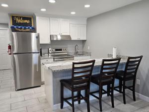 a kitchen with a stainless steel refrigerator and black chairs at Cozy Norment Forest Apartment in Lumberton
