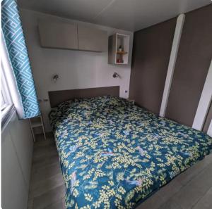 sypialnia z łóżkiem z narzutą w kwiaty w obiekcie Mobil home Premium Camping 5* w mieście Vendays-Montalivet