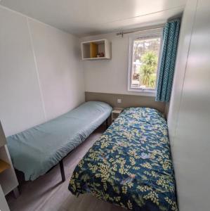 mały pokój z łóżkiem i oknem w obiekcie Mobil home Premium Camping 5* w mieście Vendays-Montalivet