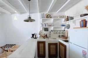 a kitchen with white walls and a white counter top at Eros Home Serifos in Serifos Chora