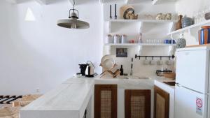 a kitchen with a white counter and a white refrigerator at Eros Home Serifos in Serifos Chora +35 photos