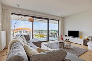 een woonkamer met een bank en een groot raam bij Boardwalk 11 O4O2 G Ii7 in Nieuwpoort