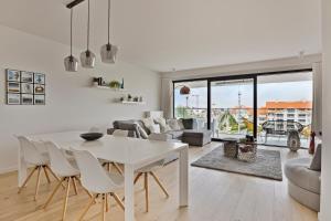 een witte woonkamer met een witte tafel en stoelen bij Boardwalk 11 O4O2 G Ii7 in Nieuwpoort
