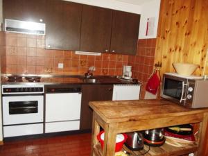 a kitchen with white appliances and a wooden table at Mayens de l Ours CZ 031 - MOUNTAIN apartment 6 per in Salins