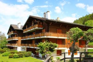 a large wooden building with balconies and trees at Mayens de l Ours CZ 031 - MOUNTAIN apartment 6 per in Salins