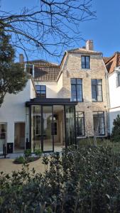 a large brick house with a glass entry way at EVERELMUS Boutique Hotel in Bruges