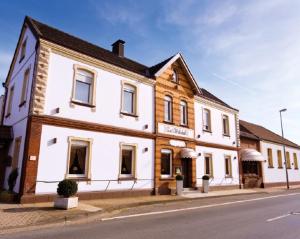 ein weißes Gebäude am Straßenrand in der Unterkunft Gasthof Tepferdt in Rees
