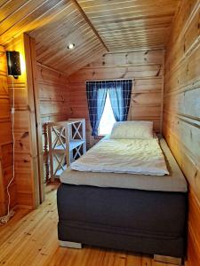 a bedroom with a bed in a wooden cabin at Loma-Otso B in Kalajoki