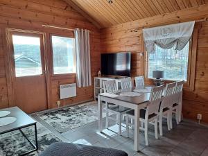a dining room with a table and chairs and a television at Loma-Otso B in Kalajoki