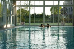 zwei Personen in einem Schwimmbad in einem Gebäude in der Unterkunft Schloss Basthorst in Crivitz