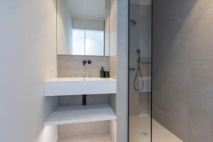 un bagno con lavandino e doccia di Sea meets sky - Ensor a Ostenda Altre 3 foto