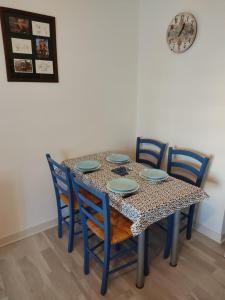 a dining room table with chairs and a clock on the wall at Appartement des machines in Nantes +4 photos