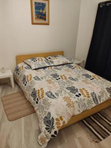 a bed with a comforter and pillows on it at Appartement des machines in Nantes
