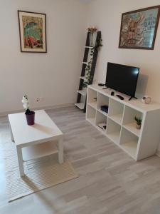 a living room with a tv and a white table at Appartement des machines in Nantes