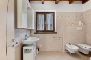 Un baño blanco con lavabo e inodoro. en Ca'della Melania, en Folgaria 34 fotos más