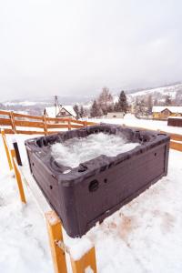 una grande scatola appoggiata su una panchina nella neve di Świerkowe Chatki w Koniakowie a Koniaków