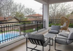 a balcony with two chairs and a swimming pool at Private Villa with 5BD, Pool & Stunning Sea Views by Flat Mаnаger in Varna City
