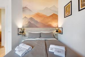 1 dormitorio con 1 cama con un mural de montaña en la pared en Ca'della Melania, en Folgaria