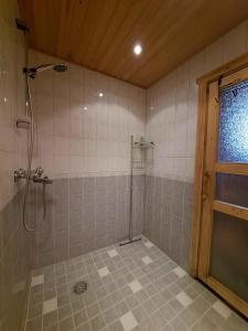 a bathroom with a shower and a tiled wall at Loma-Otso A in Kalajoki +10 photos