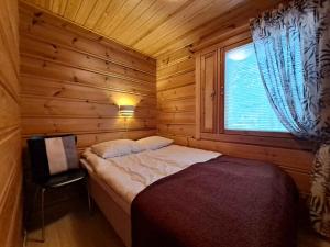 a bed in a wooden room with a window at Loma-Otso A in Kalajoki