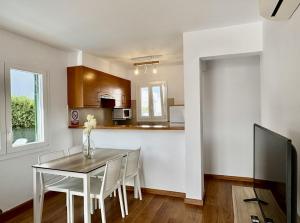 Una cocina y un comedor con mesa y sillas. en Villa Dofins, en Cala Blanca