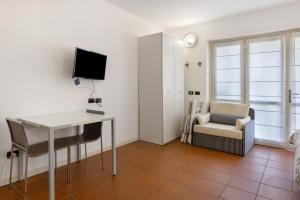 Habitación con escritorio, TV y silla. en Golf Resort Il Feudo Apt 2, en Asti