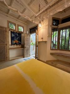 una camera con letto giallo in una stanza con finestre di Deep Blue a Matara