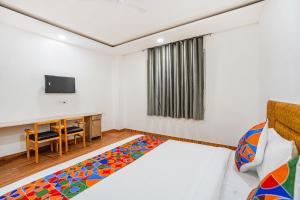 a bedroom with a bed and a desk and a tv at FabHotel Wamson in Jāmb +29 photos