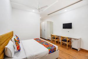 a bedroom with a bed and a desk and a television at FabHotel Wamson in Jāmb