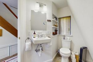 un bagno bianco con lavandino e WC di Tranquil Tides Cottage a Langley