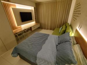 a bedroom with a bed and a flat screen tv at Malia Beach Muro Alto 300 Metros Do Mar in Porto De Galinhas +17 photos